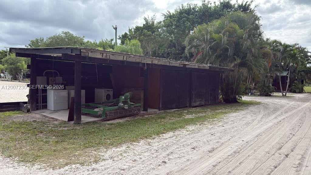 An open-sided wooden structure with a concrete floor sits on a dirt lot — 14996 50th St S, Wellington FL 33414, WELLINGTON, FL