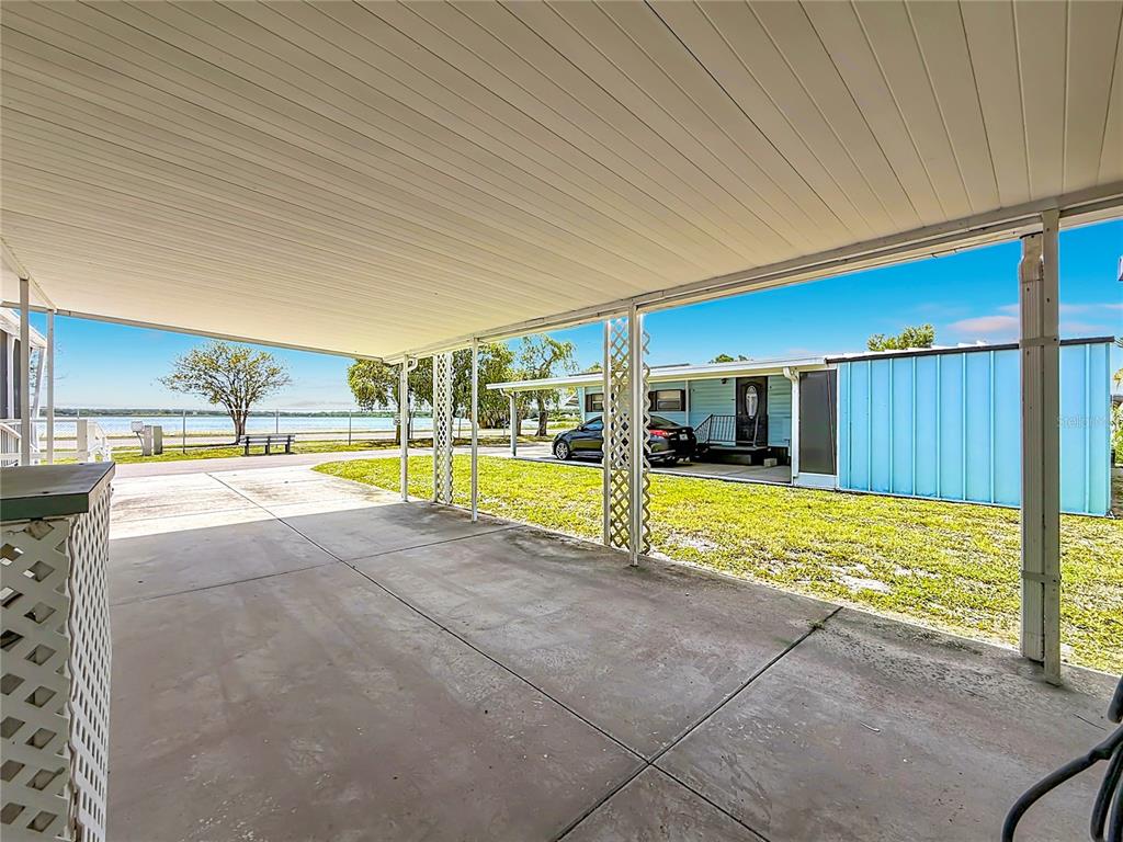 A concrete carport overlooks a grassy yard and a body of water — 800 32ND AVENUE S UNIT 727, ST PETERSBURG, FL