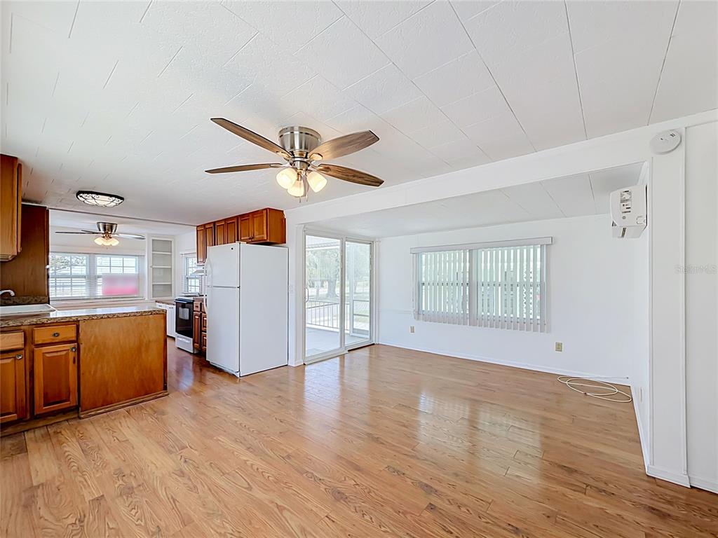 A kitchen and dining area with wood flooring, white walls, and a ceiling fan — 800 32ND AVENUE S UNIT 727, ST PETERSBURG, FL