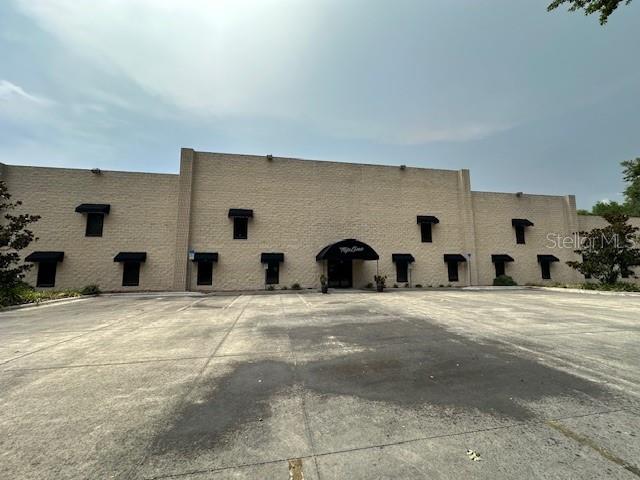 A low-rise commercial building with a tan masonry facade and black window awnings — 2251 TOPLINE WAY UNIT 4, BROOKSVILLE, FL