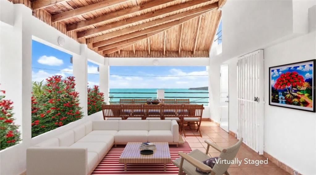 This virtually staged open-air patio features a wooden ceiling, white sofa, and ocean views — 39 COMM PLAYA GUAYANES, YABUCOA, PR