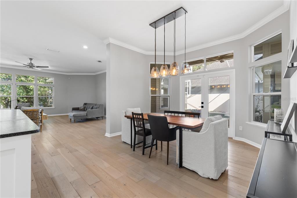 A dining area with a wooden table, pendant lights, and light wood flooring — 3636 SW 97TH WAY, GAINESVILLE, FL