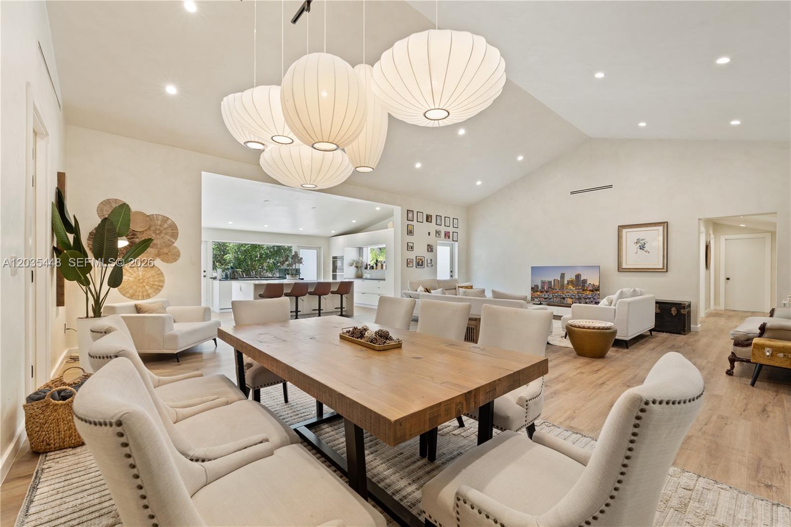 A spacious open-concept living and dining area features a large wooden table and pendant lights — 520 Bay Point Rd, Miami FL 33137, MIAMI, FL