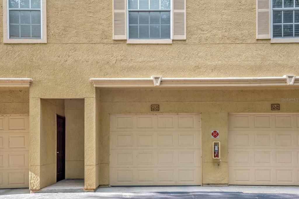 The exterior of a multi-story building features two garage doors, a side entrance, and windows — 845 GRAND REGENCY POINT UNIT 203, ALTAMONTE SPRINGS, FL
