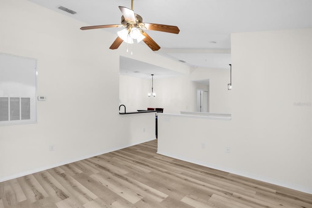 A living area with light wood-look flooring, a ceiling fan, and an open floor plan — 845 GRAND REGENCY POINT UNIT 203, ALTAMONTE SPRINGS, FL