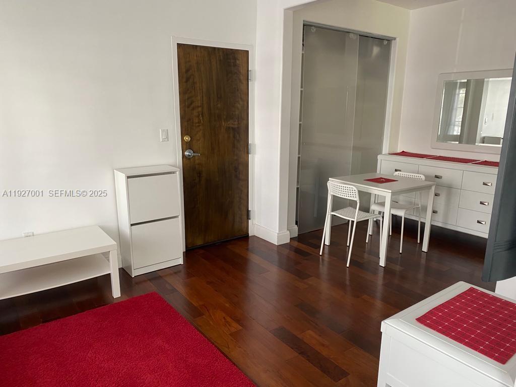 A room with dark wood flooring, a white table, chairs, and a white dresser — 526 15 ST # 2, Miami Beach FL 33139, MIAMI BEACH, FL