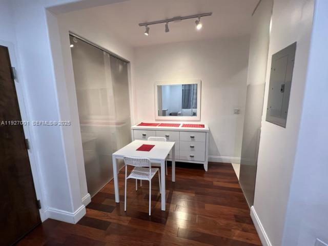 A dining area features a white table, one chair, a dresser, and dark wood flooring — 526 15 ST # 2, Miami Beach FL 33139, MIAMI BEACH, FL