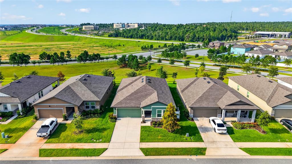 An aerial view shows a row of suburban houses with driveways and lawns — 1785 SUNDANCE CHASE ROAD, MINNEOLA, FL