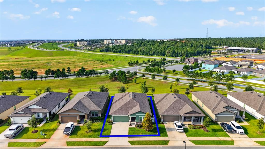 An aerial view shows a row of suburban houses with a blue outline highlighting one home — 1785 SUNDANCE CHASE ROAD, MINNEOLA, FL