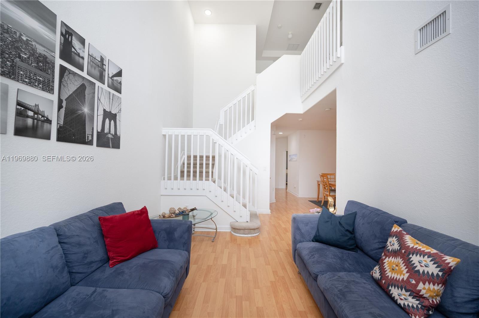 A living room features two blue sofas, a staircase, and a gallery wall of photos — 14964 SW 8 LN, Miami FL 33194, MIAMI, FL