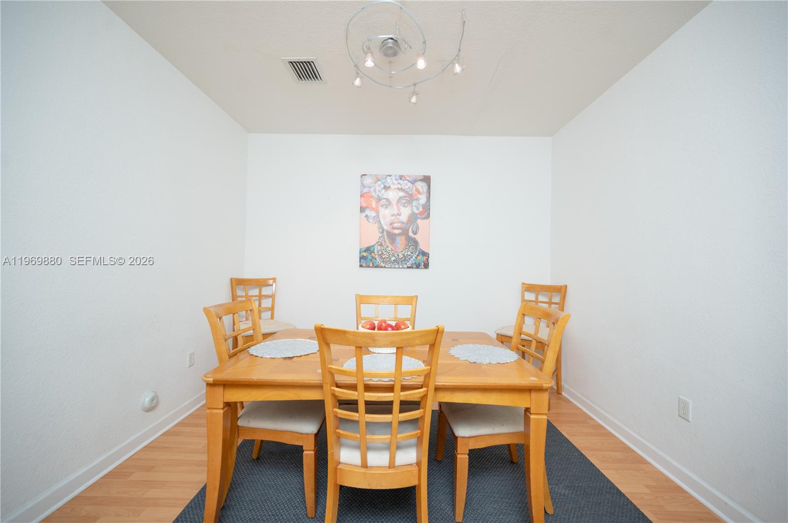 A dining room features a wooden table, four chairs, and a portrait on the wall — 14964 SW 8 LN, Miami FL 33194, MIAMI, FL