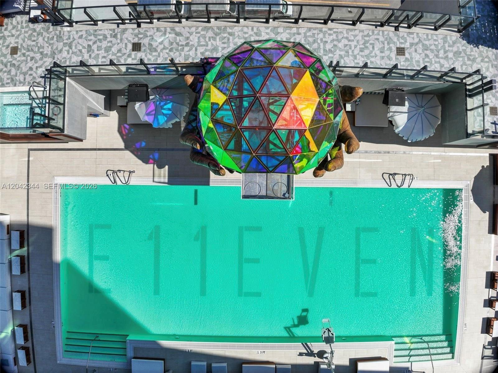 An aerial view of a swimming pool with E11EVEN branding and a large geometric sculpture — 20 NE 11th st # 4604, Miami FL 33132, MIAMI, FL