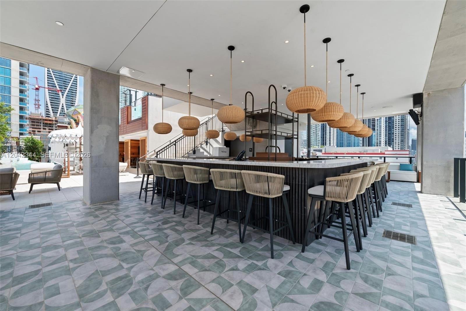An outdoor bar area features woven pendant lights, bar stools, and patterned tile flooring — 20 NE 11th st # 4604, Miami FL 33132, MIAMI, FL