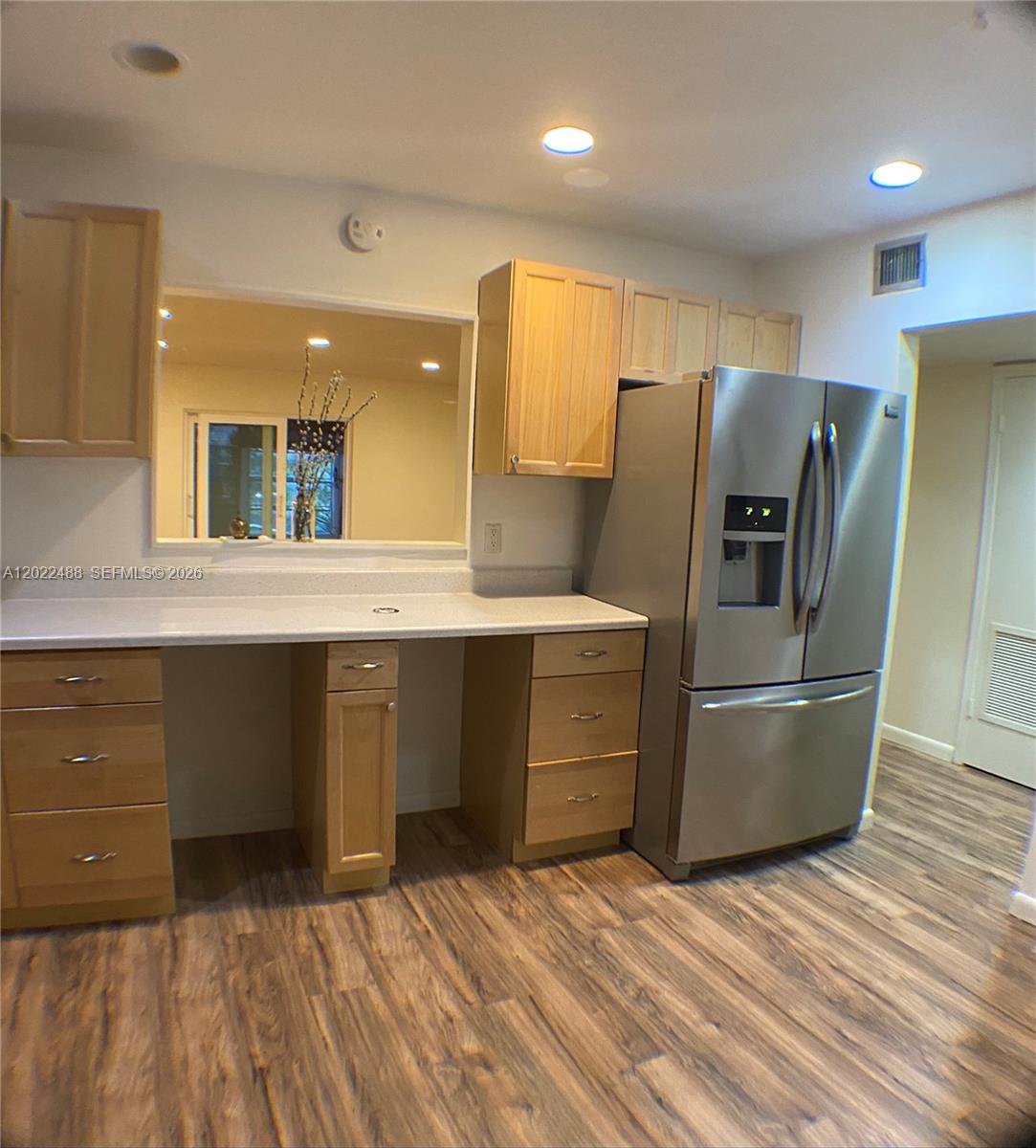 A kitchen features light wood cabinets, stainless steel appliances, and a pass-through window — 2061 NW 47th Ter # 302, Lauderhill FL 33313, LAUDERHILL, FL