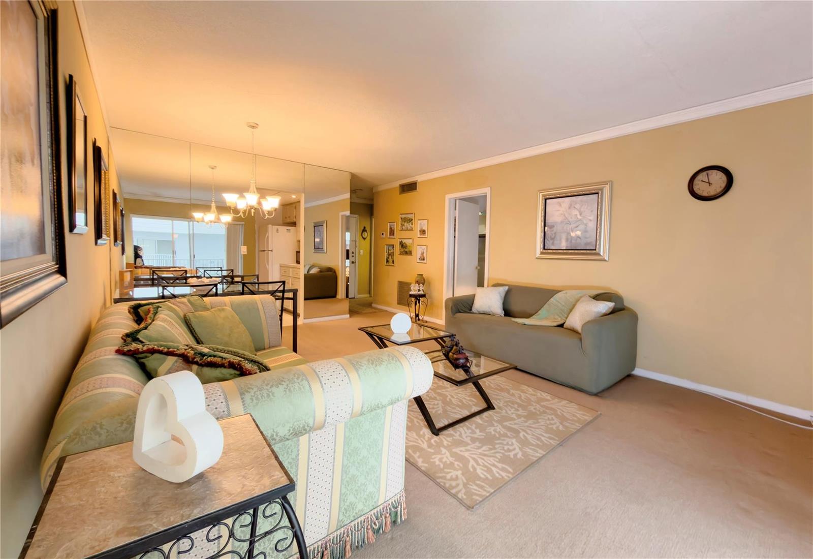 A living room features two sofas, a glass coffee table, and a large mirrored wall — 412 S Cypress Road # 225, Pompano Beach FL 33060, POMPANO BEACH, FL