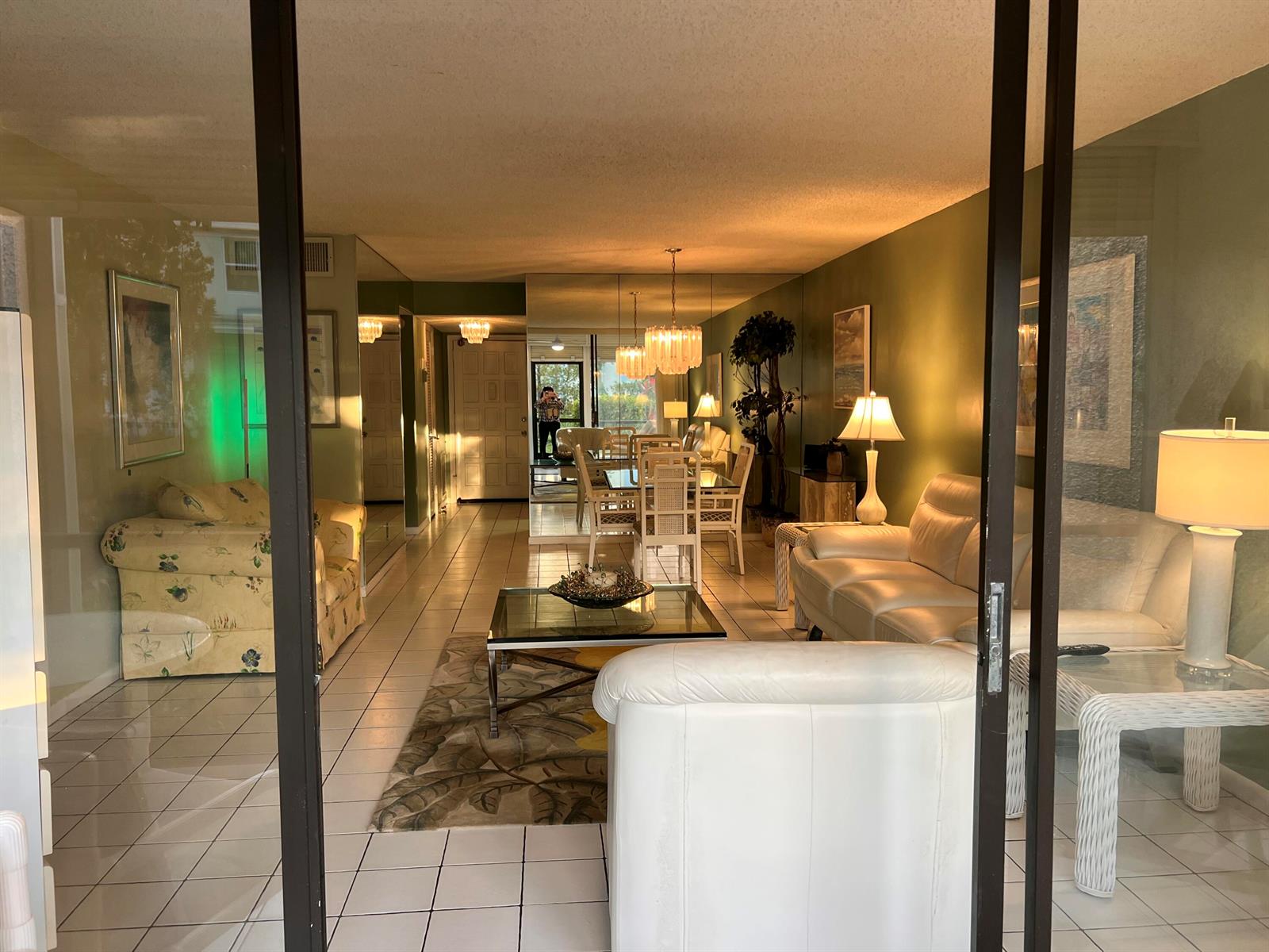 A living and dining area with tiled floors, white leather furniture, and mirrored walls — 4387 Trevi Court, FL 33467, FL