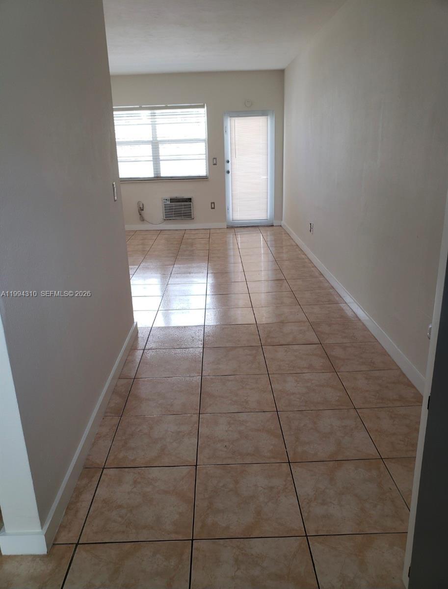 A room with light-colored tile flooring, a window, and a glass-paneled door — 620 76th St # 11, Miami Beach FL 33141, MIAMI BEACH, FL