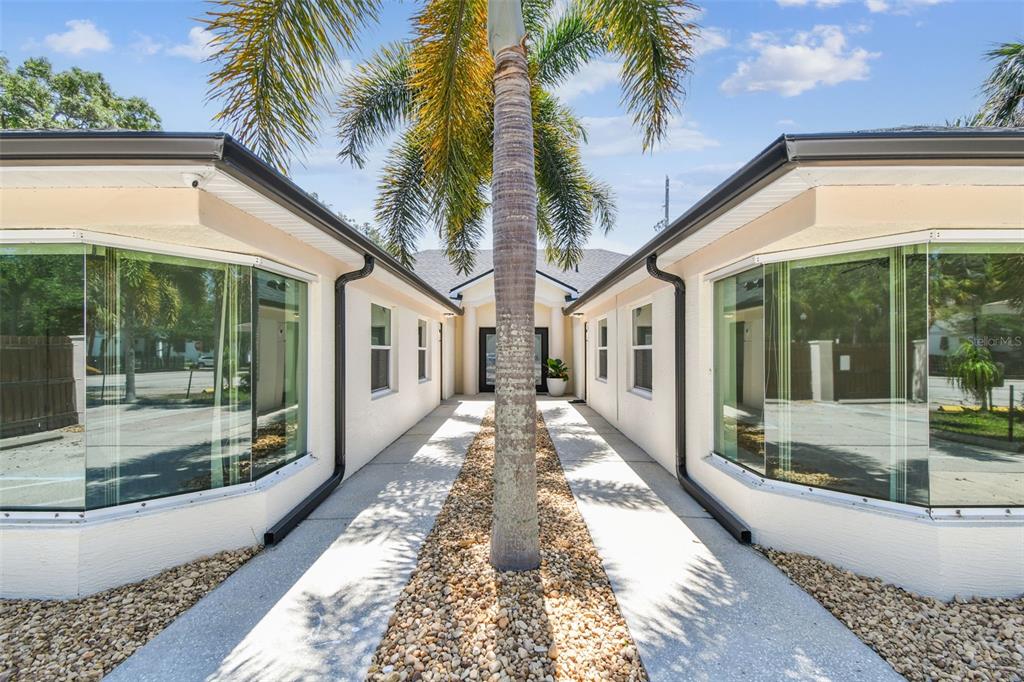 A palm tree stands in the center of a walkway between two symmetrical building wings — 670 2ND STREET N, SAFETY HARBOR, FL