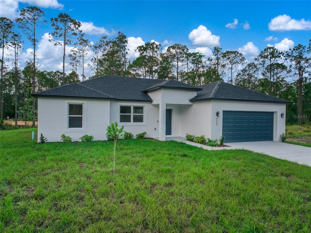A single-story white house with a dark roof and garage sits on a grassy lot — 4225 GERONA AVENUE, SEBRING, FL