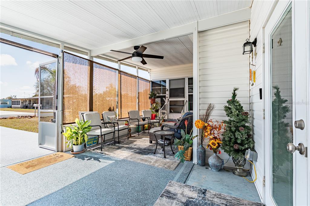A screened-in porch features a ceiling fan, outdoor furniture, and a view of the neighborhood — 39437 ELGIN DRIVE, ZEPHYRHILLS, FL