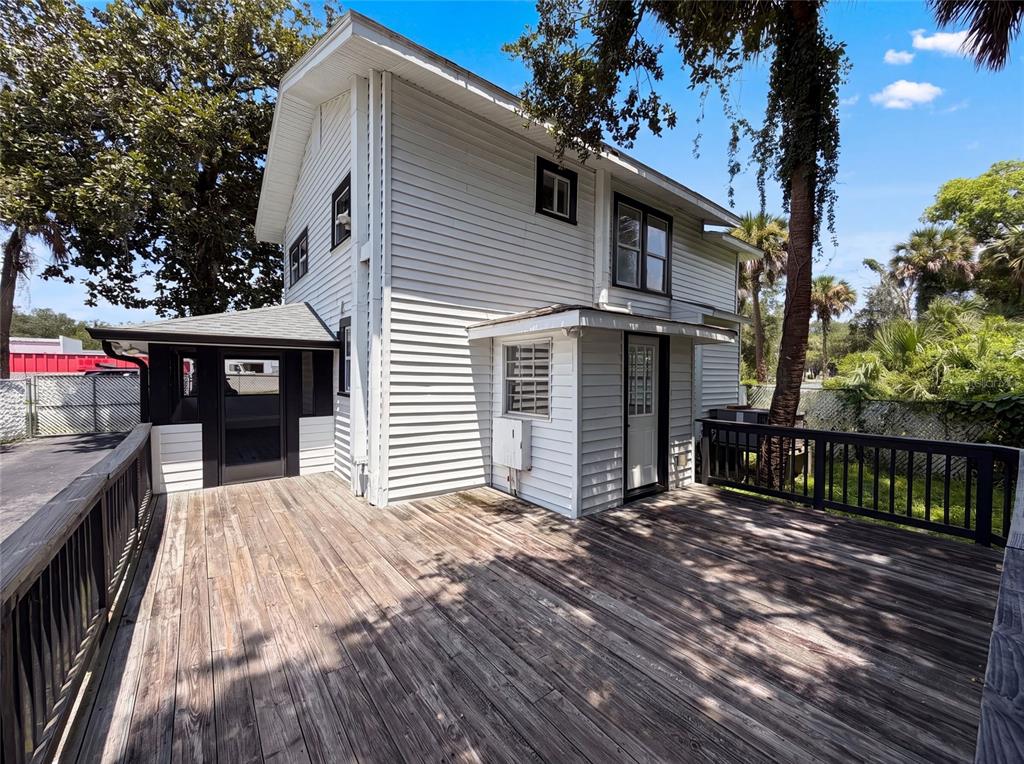 A two-story white house features a large wooden deck and black-trimmed windows and doors — 111 S OLEANDER AVENUE, SANFORD, FL