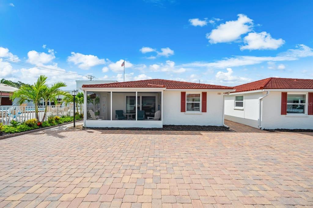 A single-story house with a screened-in porch and red tile roof sits on a paved lot — 6154 MIDNIGHT PASS ROAD UNIT B1, SARASOTA, FL