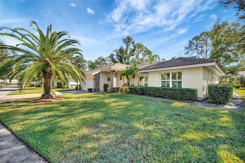 A single-story house with a palm tree, manicured lawn, and a tiled roof — 5721 GARDEN LAKES MAJESTIC, BRADENTON, FL