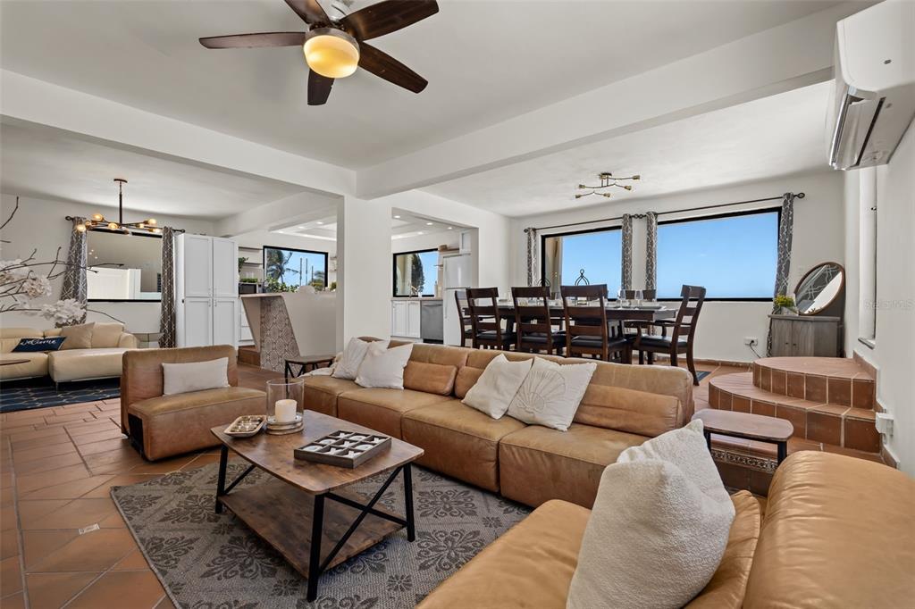 A living room and dining area feature tan leather sofas, tile flooring, and ocean views — 91 G KENNEDY STREET, DORADO, PR