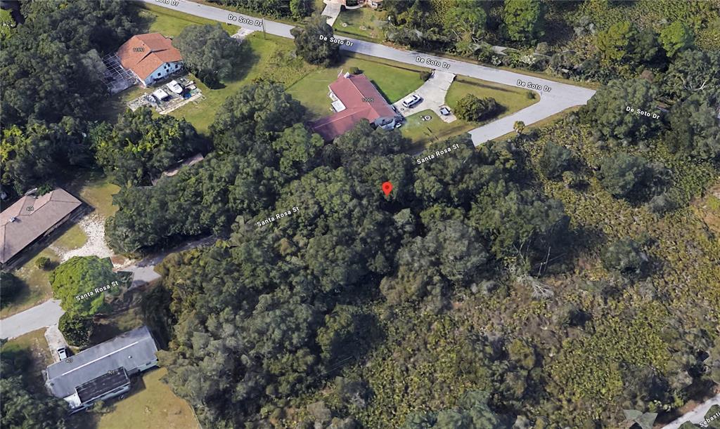 An aerial view shows a wooded, undeveloped lot located at a street intersection — SANTA ROSA STREET, NORTH PORT, FL