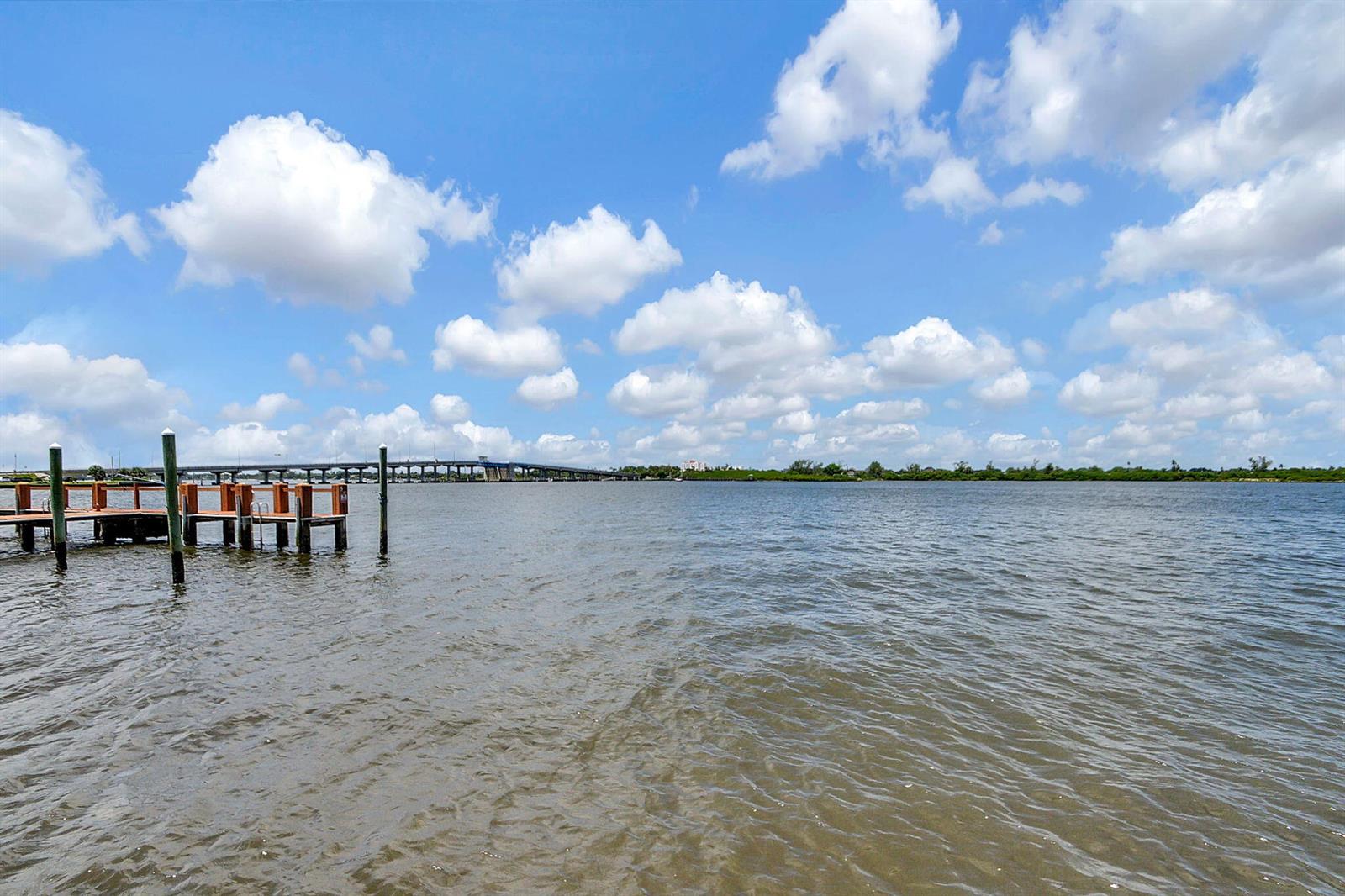 A wooden dock extends into a wide body of water with a bridge in the distance — 2840 S Ocean Boulevard # 3020, Palm Beach FL 33480, PALM BEACH, FL