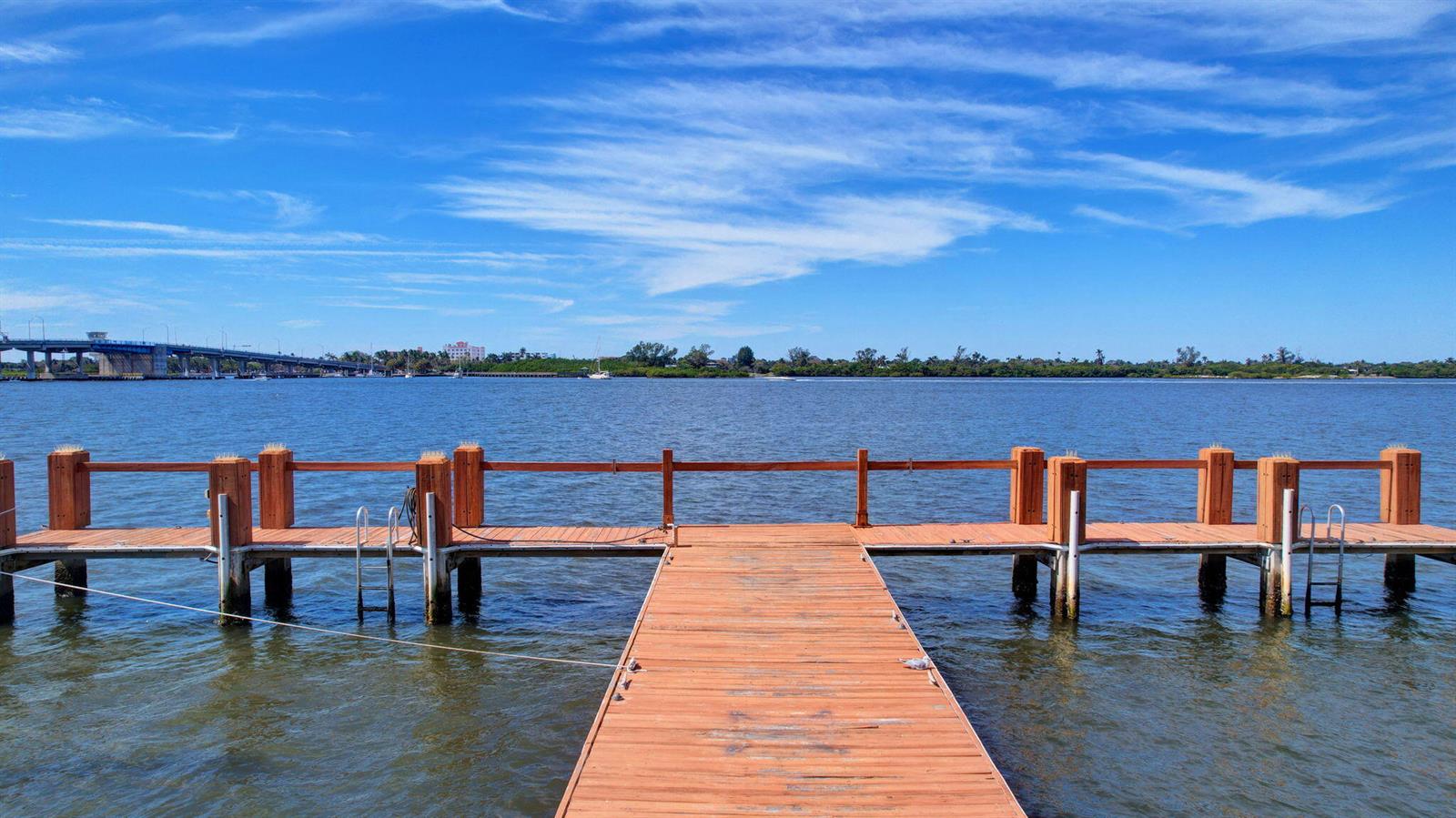 A wooden dock extends into a calm bay under a bright blue sky — 2840 S Ocean Boulevard # 3020, Palm Beach FL 33480, PALM BEACH, FL