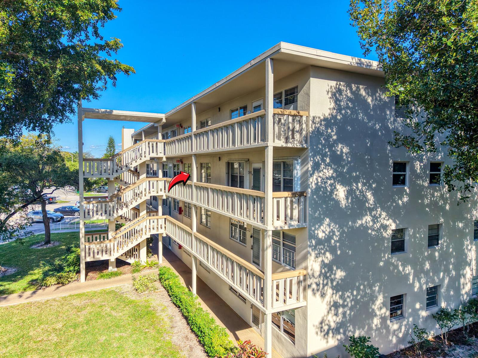 An exterior view of a multi-story apartment building with open-air walkways and a metal staircase — 3002 Ventnor # G, Deerfield Beach FL 33442, DEERFIELD BEACH, FL