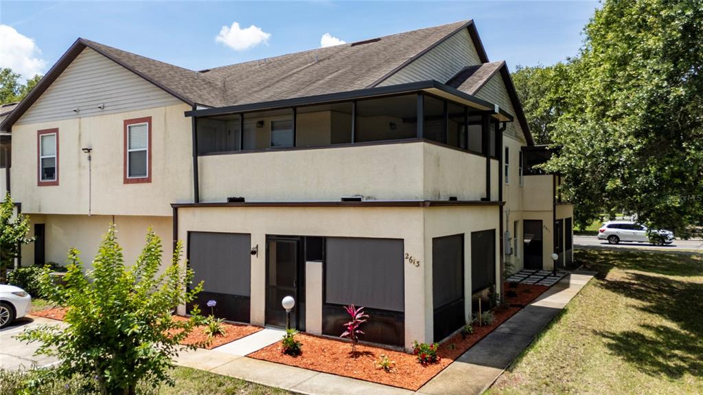 A two-story building features a screened-in porch on the ground level and a balcony above — 2613 S PARK AVENUE, TITUSVILLE, FL