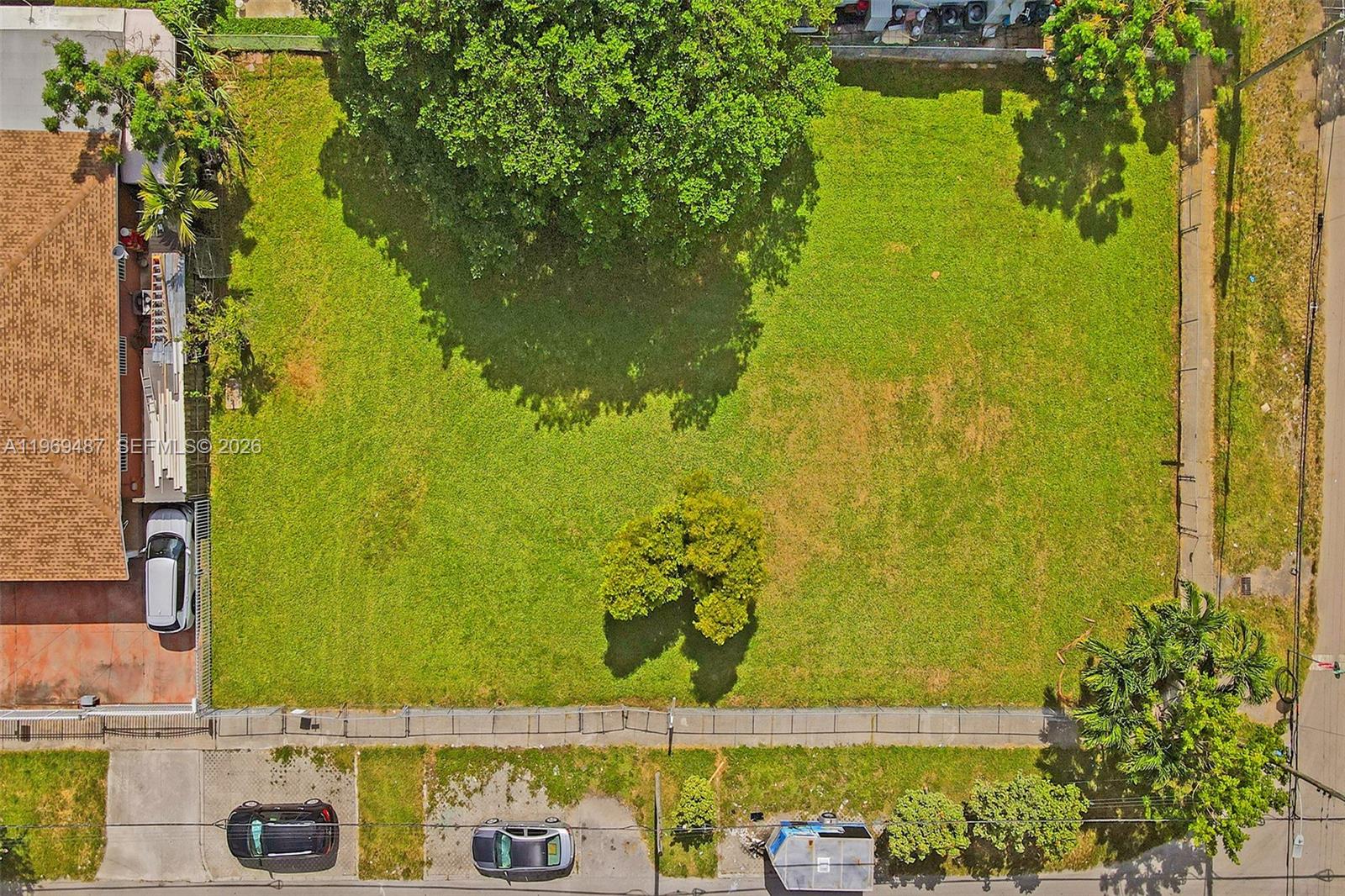 An aerial view shows a rectangular vacant grassy lot enclosed by a chain-link fence — 2397 NW 34th St, Miami FL 33142, MIAMI, FL