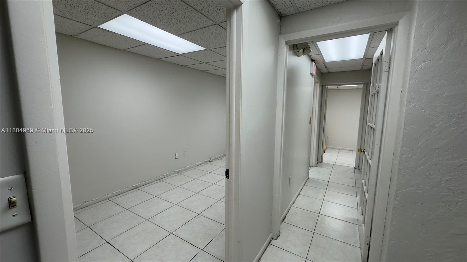 A hallway leads to an interior office space with white tile floors and drop ceilings — 8315 SW 24th St # B, Miami FL 33155, MIAMI, FL