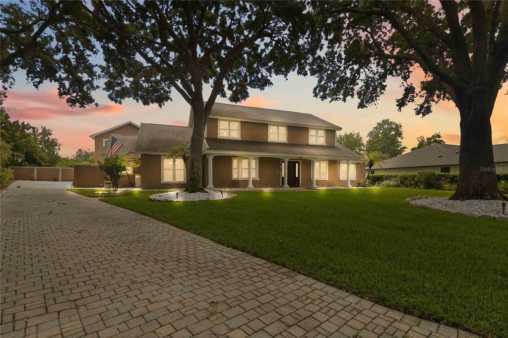 A two-story house with a paved driveway and large trees on a grassy lawn — 5333 GREENSIDE COURT, ORLANDO, FL