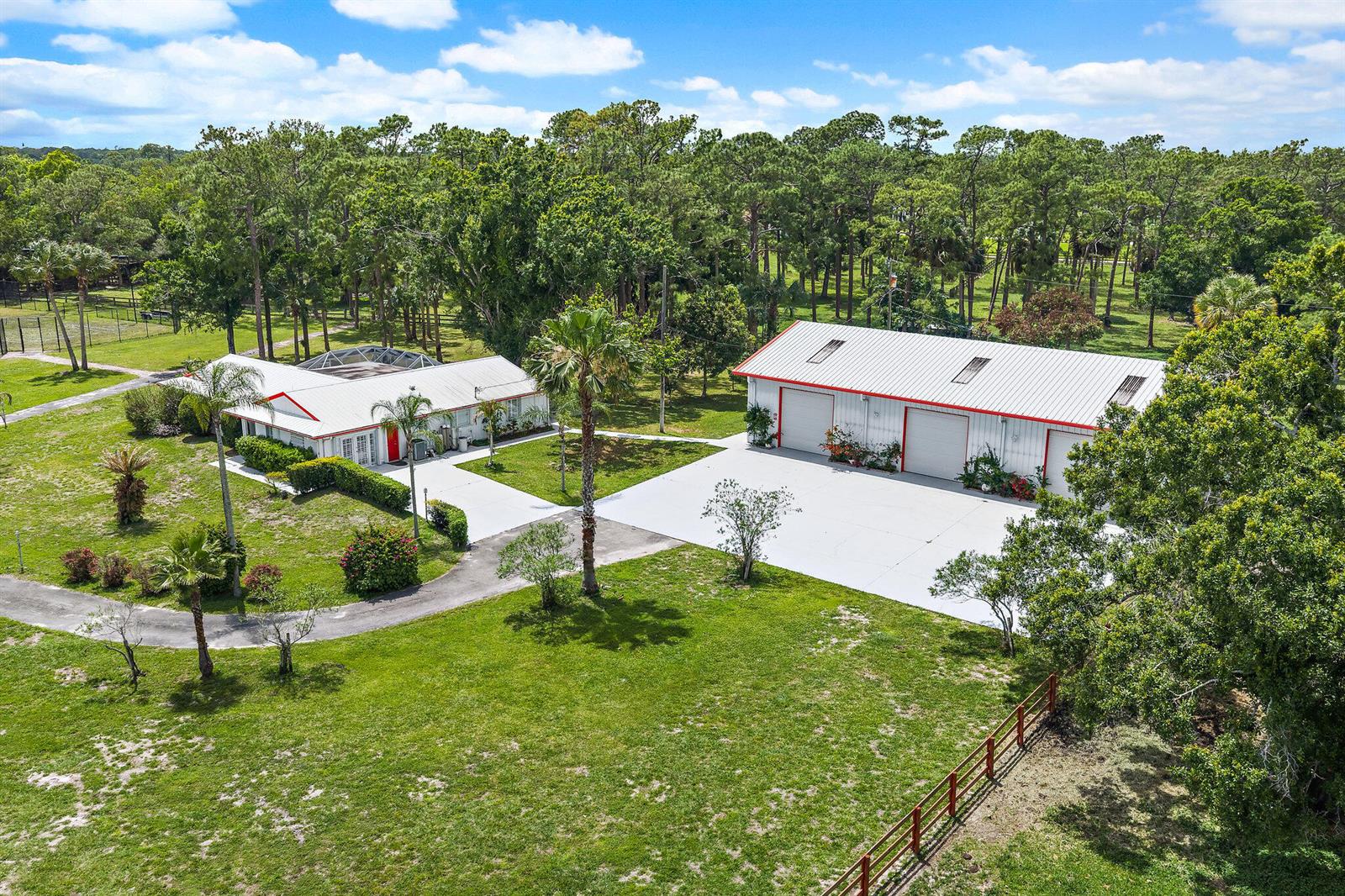 An aerial view shows a house with a pool enclosure and a detached three-bay garage — 16411 Jupiter Farms Road, Jupiter FL 33478, JUPITER, FL