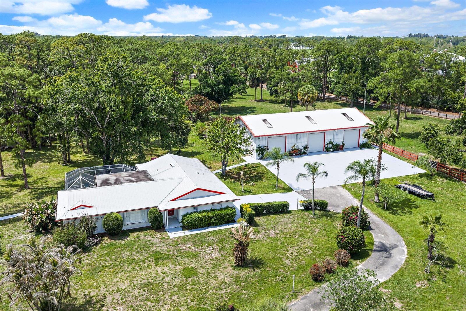 An aerial view shows a house with a pool enclosure and a large detached garage — 16411 Jupiter Farms Road, Jupiter FL 33478, JUPITER, FL