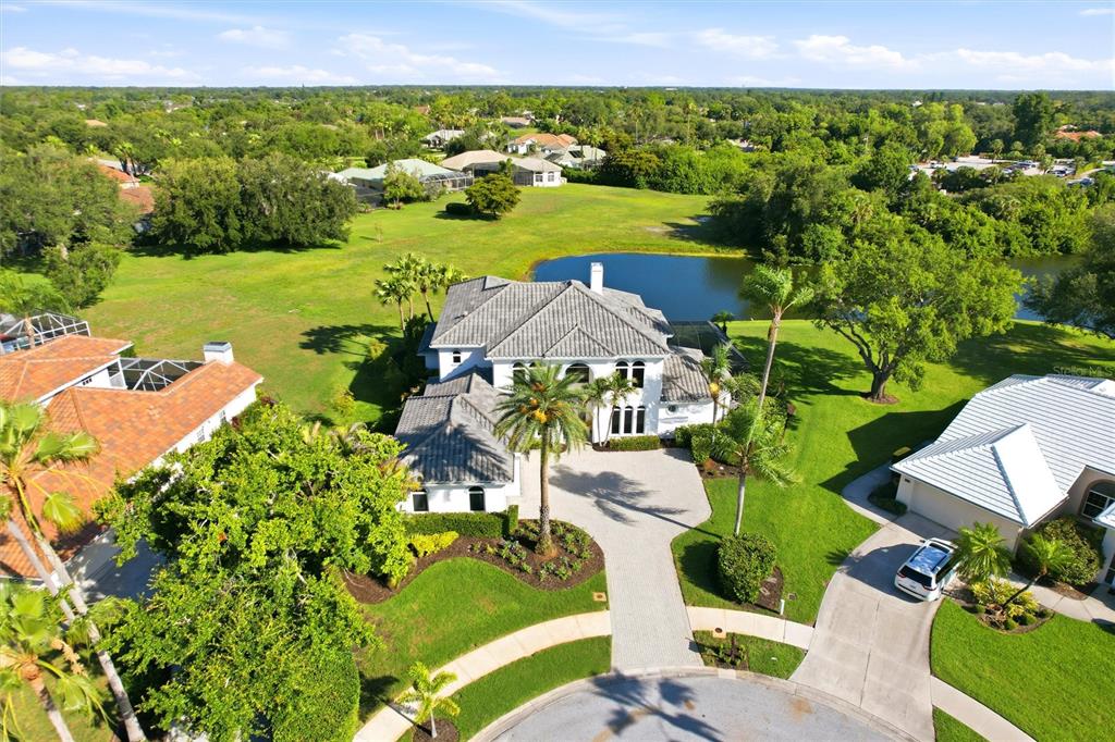 An aerial view shows a large white house with a gray roof near a pond — 8417 LONE EAGLE WAY, SARASOTA, FL