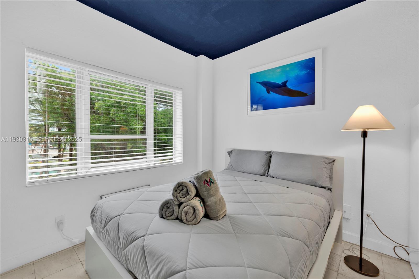 A bedroom features a bed with gray bedding, a dolphin print, and a dark blue ceiling — 255 W 24th St # 302, Miami Beach FL 33140, MIAMI BEACH, FL