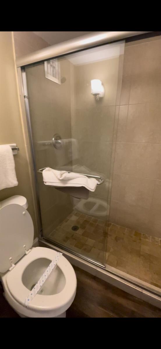 A bathroom featuring a toilet and a glass-enclosed walk-in shower with tiled walls — 2555 9th Street N # 152, Naples FL 34103, NAPLES, FL