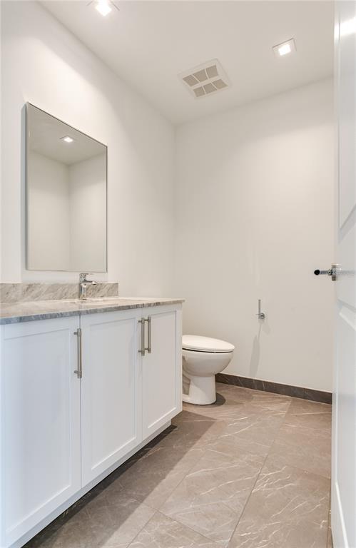 A modern bathroom features a white vanity with a marble countertop and gray tiled floors — 3015 S YSABELLA AVENUE UNIT 2401, TAMPA, FL