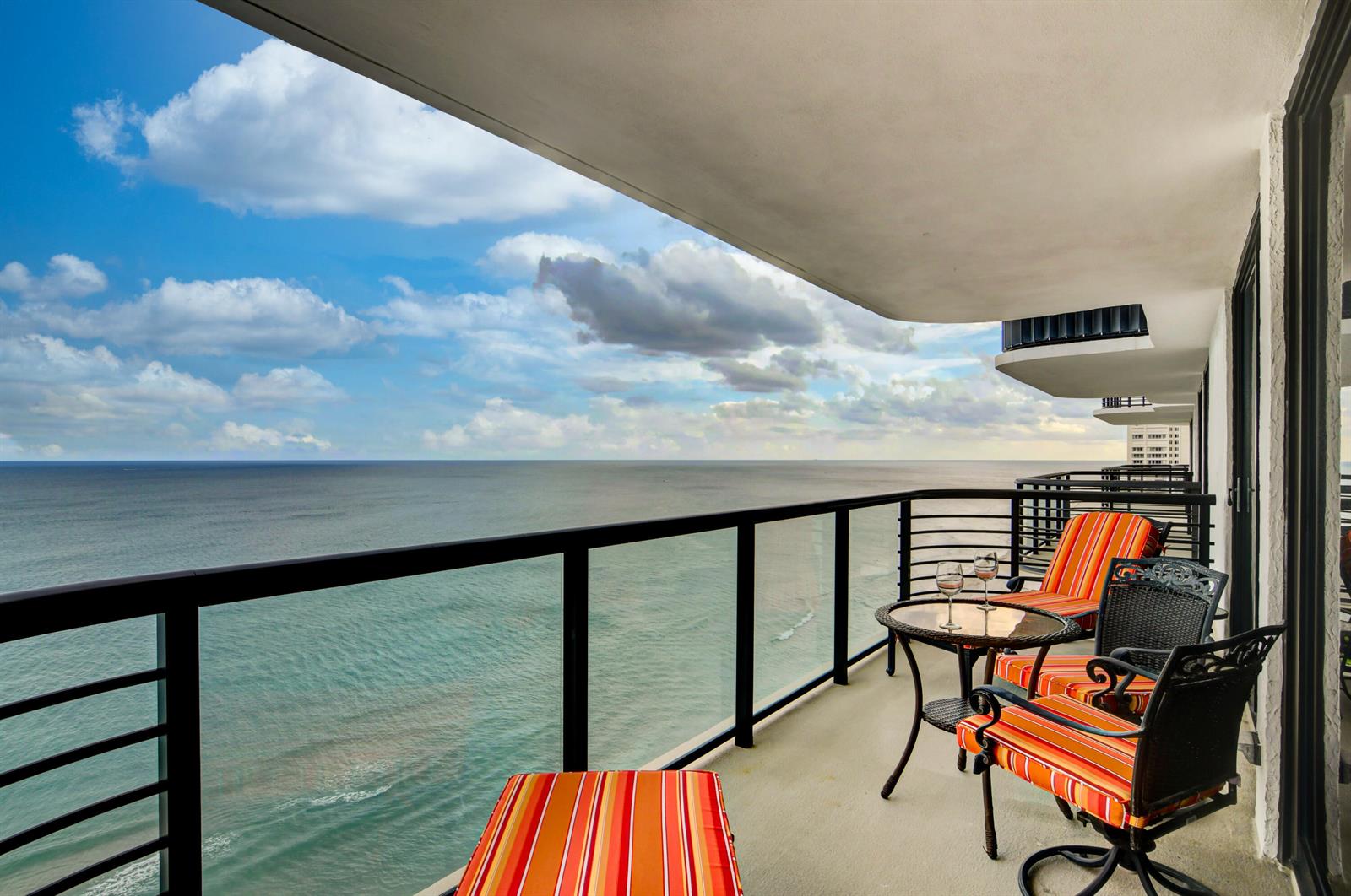 A balcony with outdoor furniture overlooks the ocean under a cloudy blue sky — 250 S Ocean Boulevard # c, Boca Raton FL 33432, BOCA RATON, FL