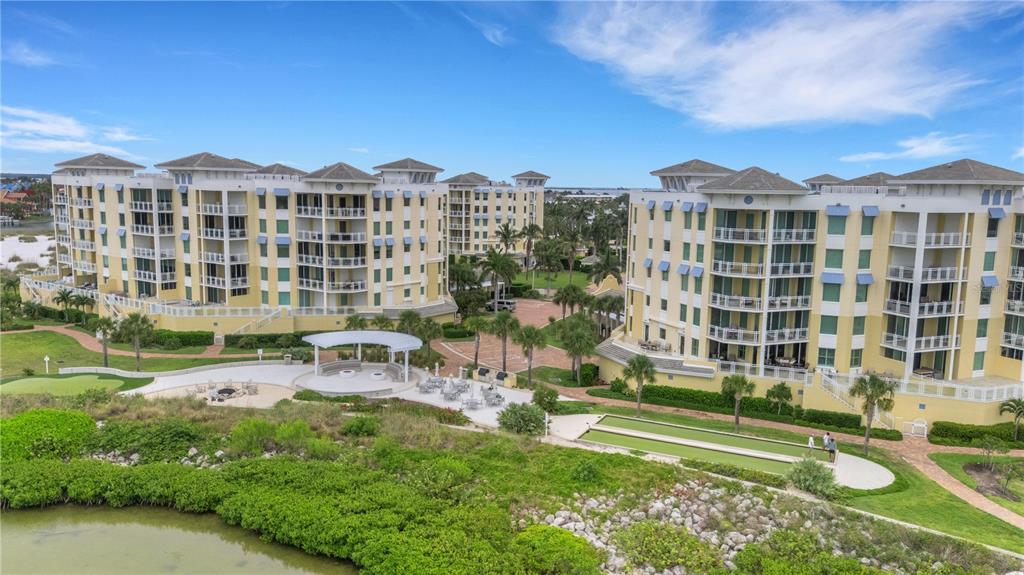 An aerial view of two large yellow apartment buildings with a shared courtyard and lawn — 795 COLLANY ROAD UNIT 304, ST PETERSBURG, FL
