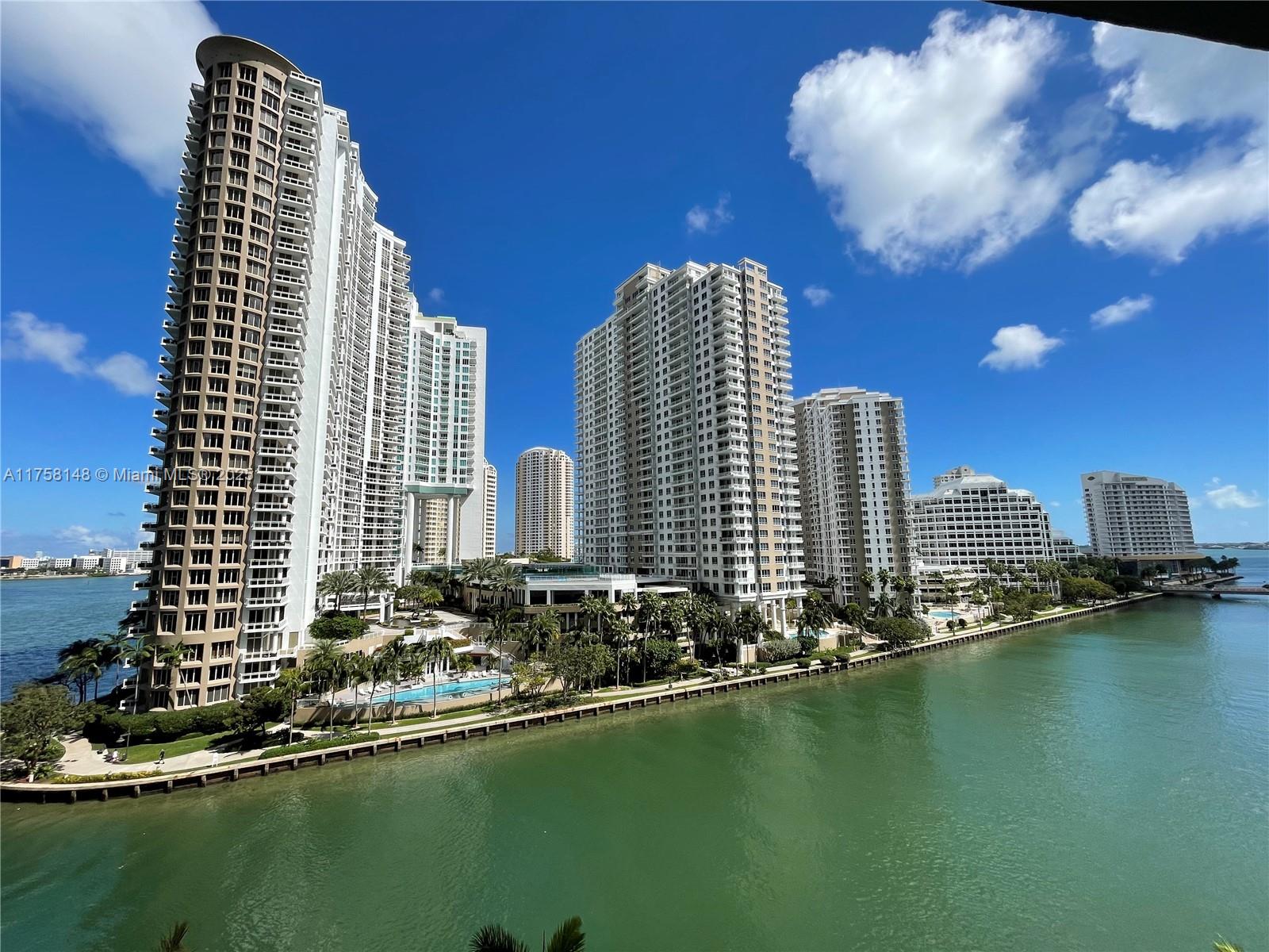 A view of several high-rise residential buildings along a waterfront with a swimming pool — 465 Brickell Ave # 819, Miami FL 33131, MIAMI, FL