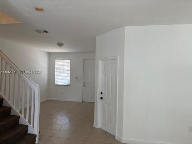 An interior view shows a tiled living area with a staircase and two white doors — 10762 NW 80th Ln, Doral FL 33178, DORAL, FL