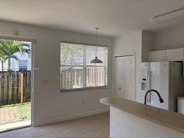 A kitchen with a breakfast bar, white refrigerator, and a sliding door to a patio — 10762 NW 80th Ln, Doral FL 33178, DORAL, FL