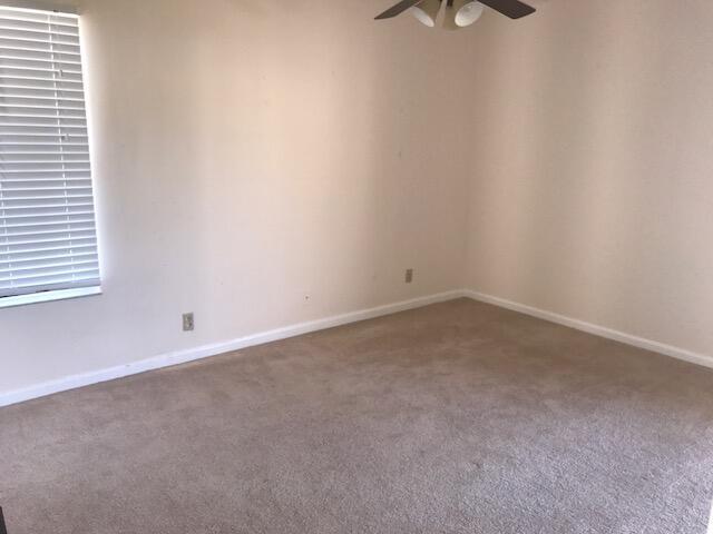 An empty bedroom features beige carpet, off-white walls, a ceiling fan, and white window blinds — 2650 Greenwood # G216, Boca Raton FL 33431, BOCA RATON, FL