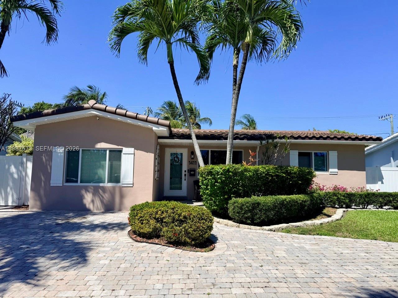 A single-story house with a paved driveway, palm trees, and a manicured hedge — 1411 Harding St, Hollywood FL 33020, HOLLYWOOD, FL
