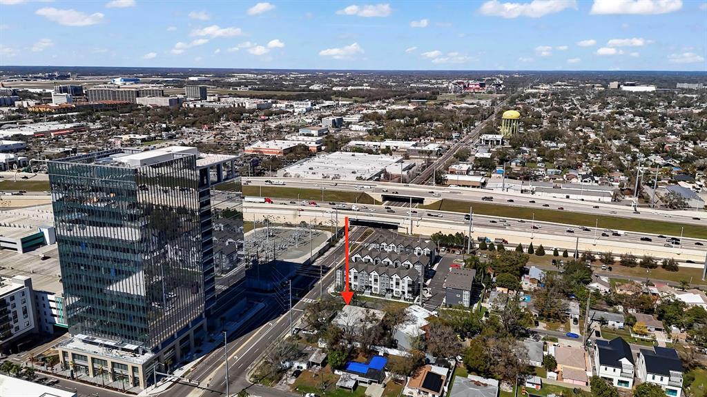An aerial view shows a red arrow pointing toward a residential property near a highway — 1207 N HIMES AVENUE UNIT 2, TAMPA, FL